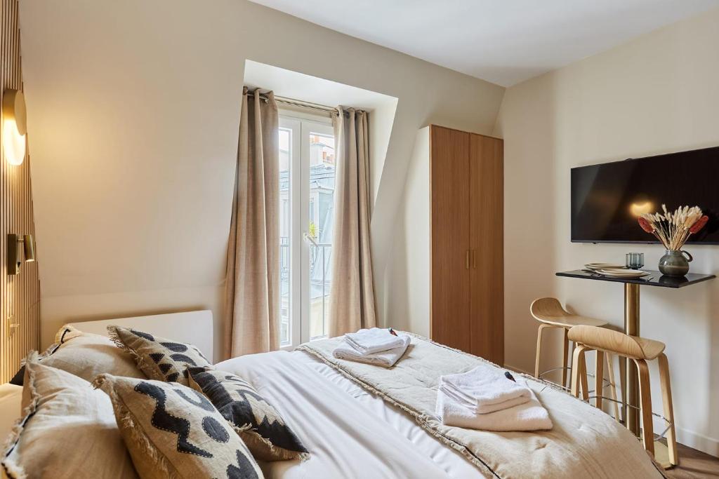 une chambre avec un lit et une télévision au mur dans l'établissement Superbe Studio Tour Eiffel Trocadero by Studioprestige, à Paris