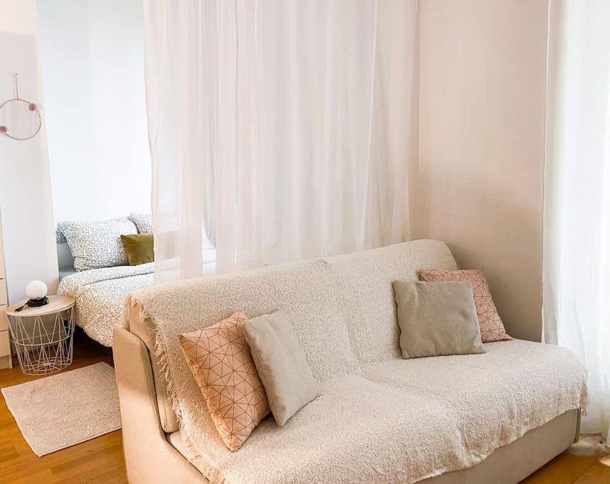 - un salon avec un canapé et des oreillers dans l'établissement une pièce Cosy à 5 Min de la Tour Eiffel à pied, à Paris