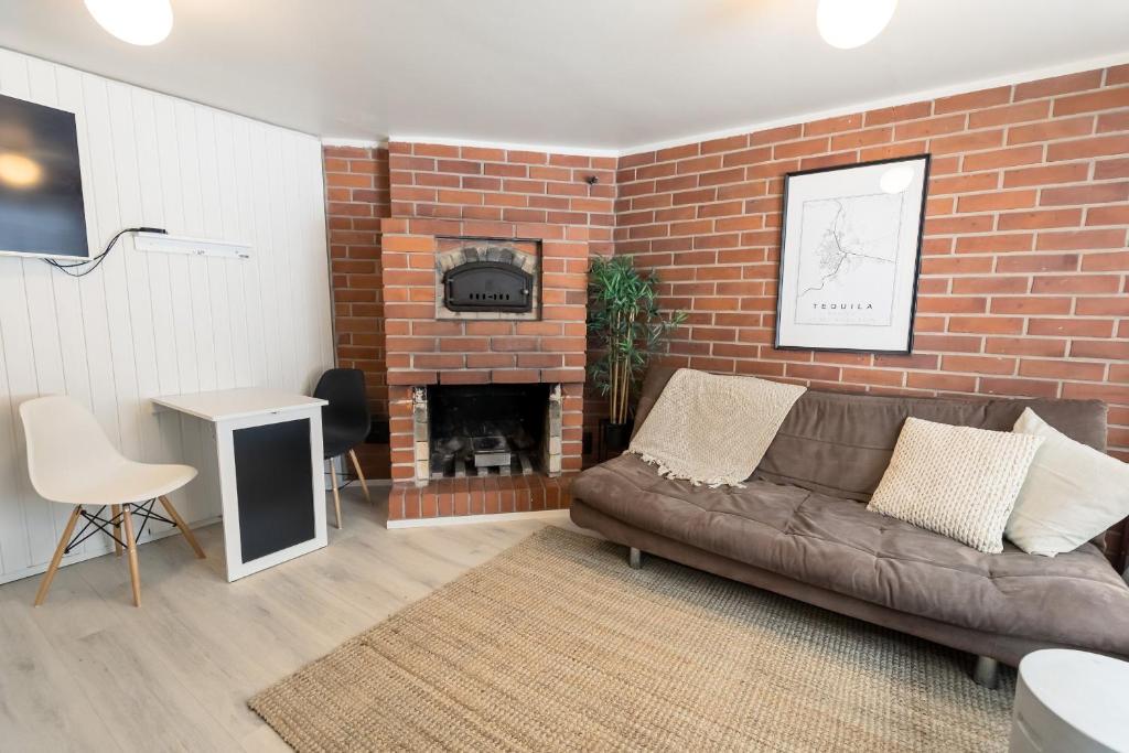 a living room with a couch and a brick wall at BohoSauna in Oulu