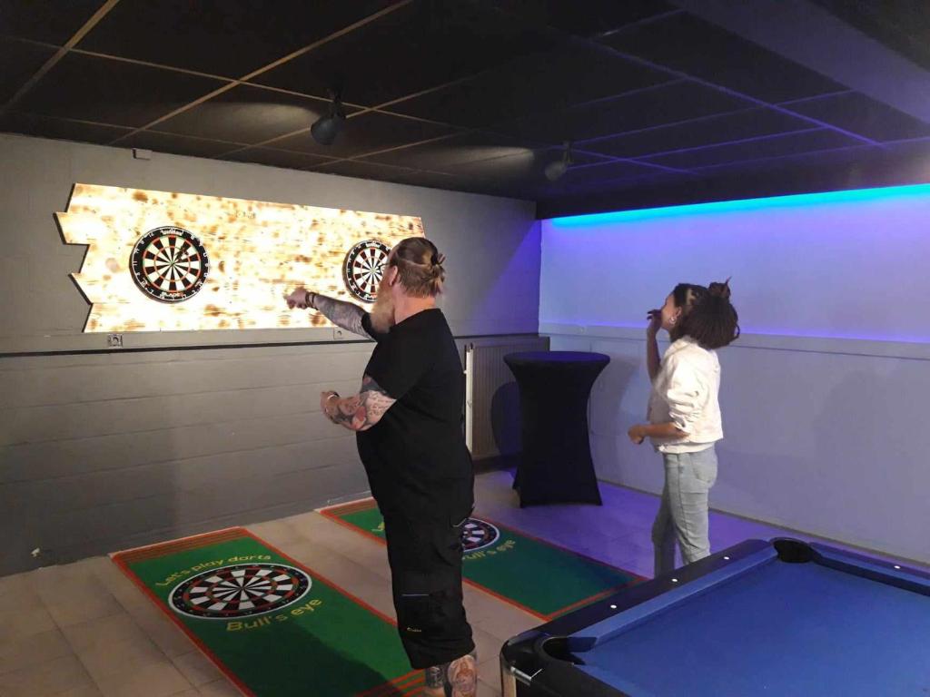 two women playing a video game in a game room at Domaine Long Pre in Stavelot