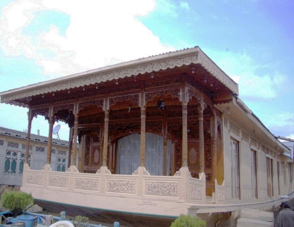 a white building with a balcony on top of it at New Lucky Star Group of Houseboats in Srinagar