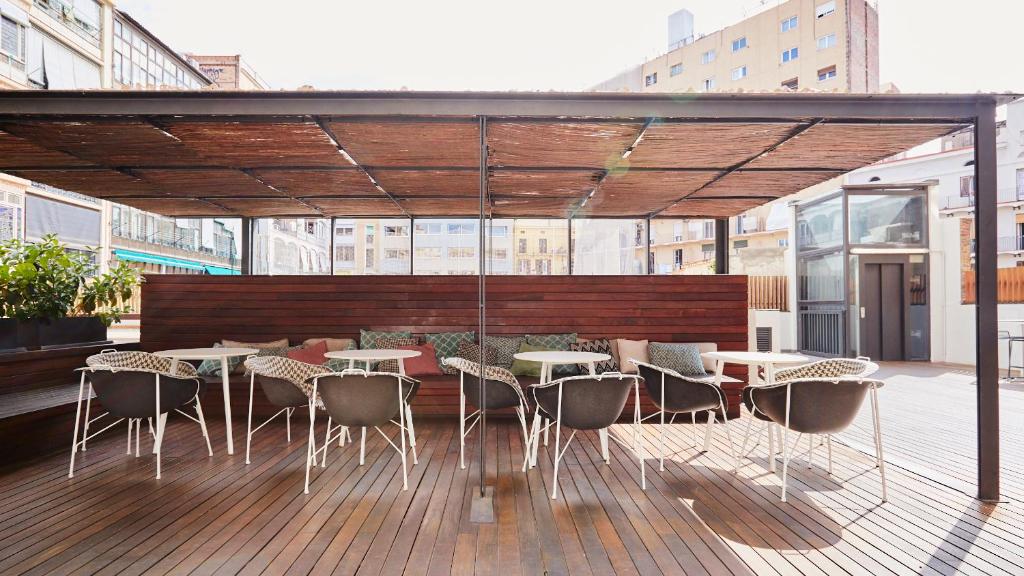 a patio with tables and chairs on a deck at TOC Hostel Barcelona in Barcelona