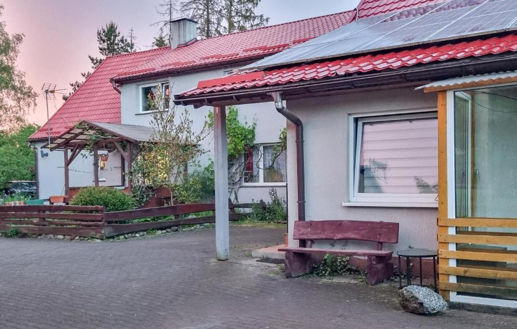 a white house with a red roof and a bench at 2 Bedroom Cozy Home In Rekowo in Rekowo