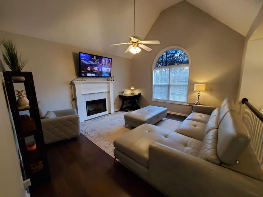 a living room with a couch and a fireplace at Lovely 5 Bedrooms, 3 Full Baths Home Near Parks! in Austell