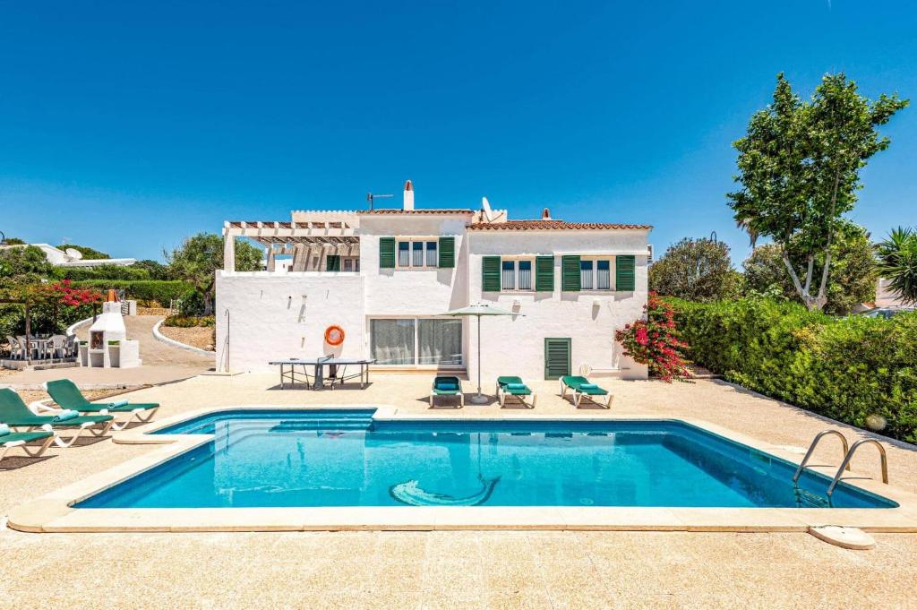 a villa with a swimming pool in front of a house at Villa Bini Anna by Villa Plus in Binibeca