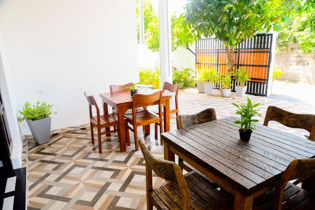 a patio with wooden tables and chairs and plants at Mario Family Villa and Restaurant in Negombo