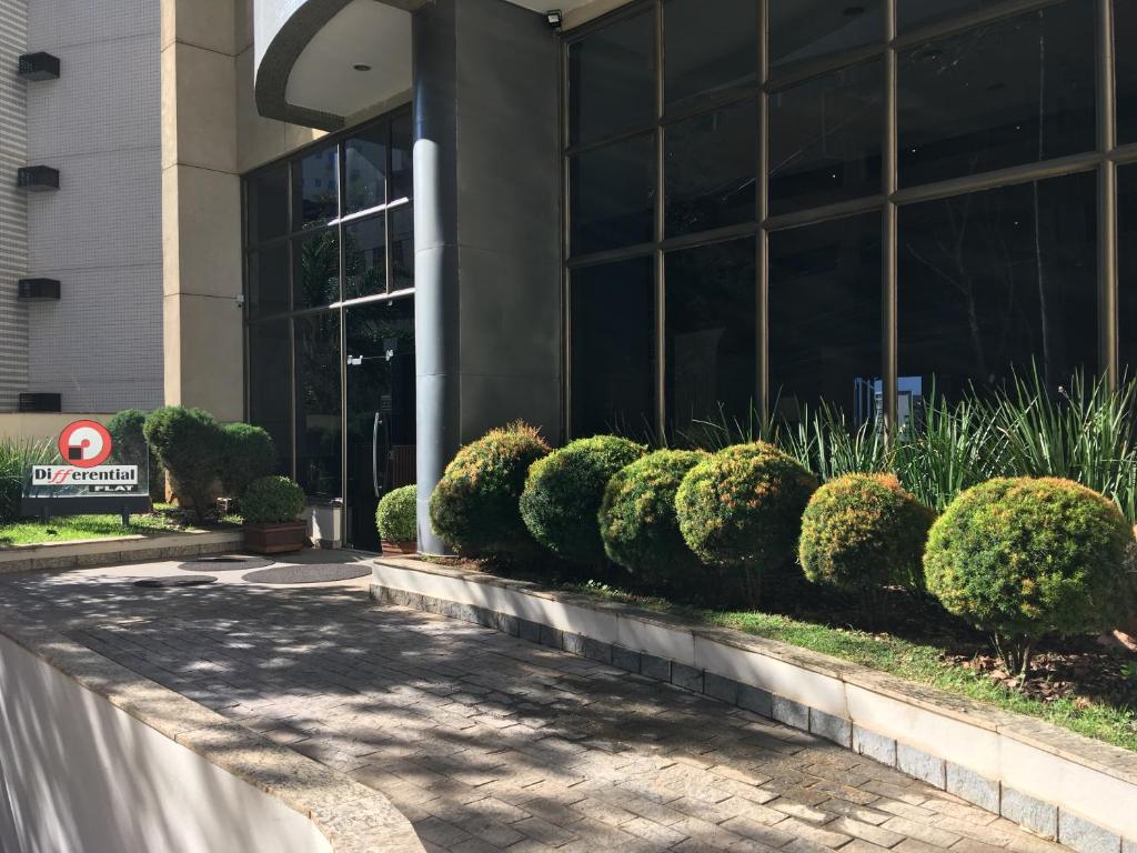 una fila di cespugli di fronte a un edificio di Differential Flat a Belo Horizonte