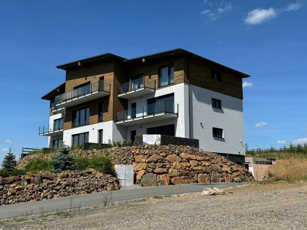 a building on top of a pile of rocks at Apartmány Horizont in Loučná pod Klínovcem