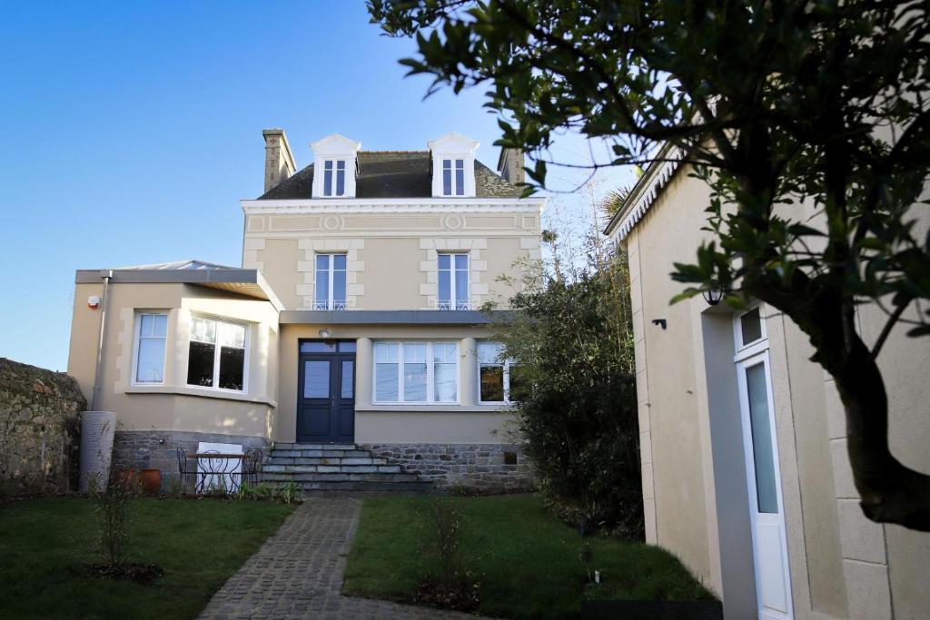 a white house with a blue door at Villa thi bai in Saint Malo
