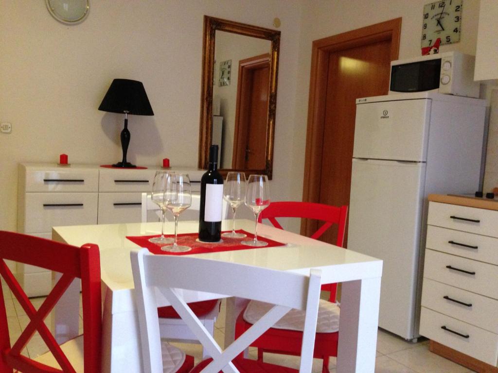 a kitchen with a table with wine glasses and a refrigerator at Villa Jasmin in Bol