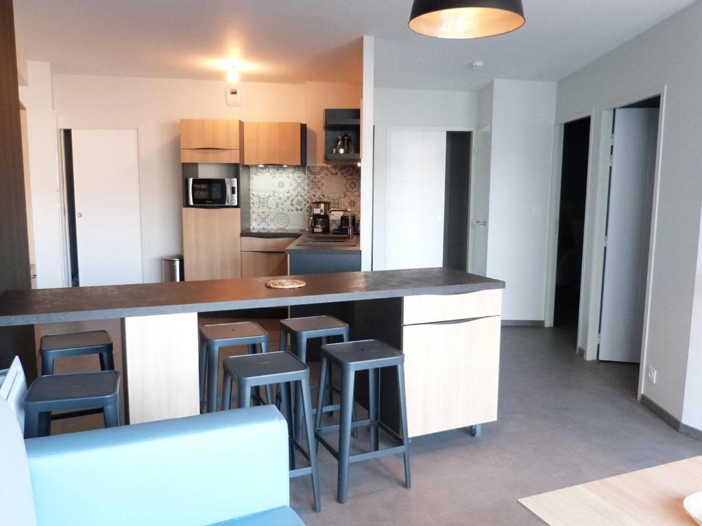 a kitchen with a large counter and stools at Appartement PMR 2 Chambres, Face Plage, Piscine, Balcon, Pour 6 Personnes, Animaux Admis - FR-1-194-222 in La Tranche-sur-Mer
