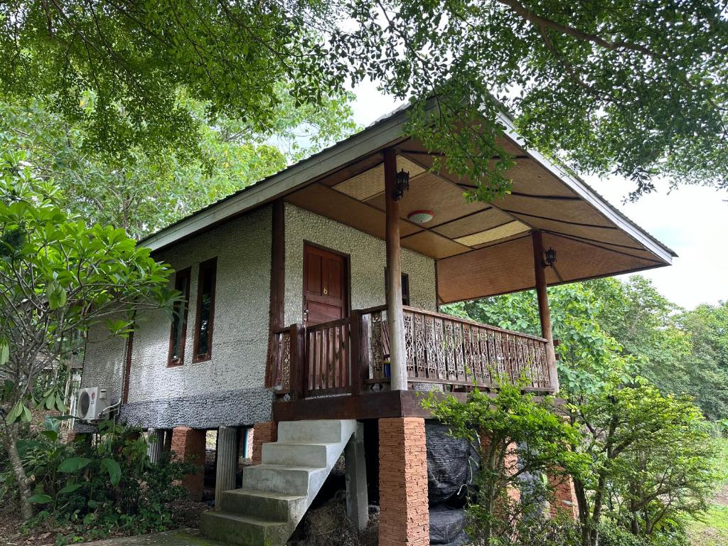 a small house with a porch and stairs to it at FourTwoEight Pai Resort in Kampong Huaibū