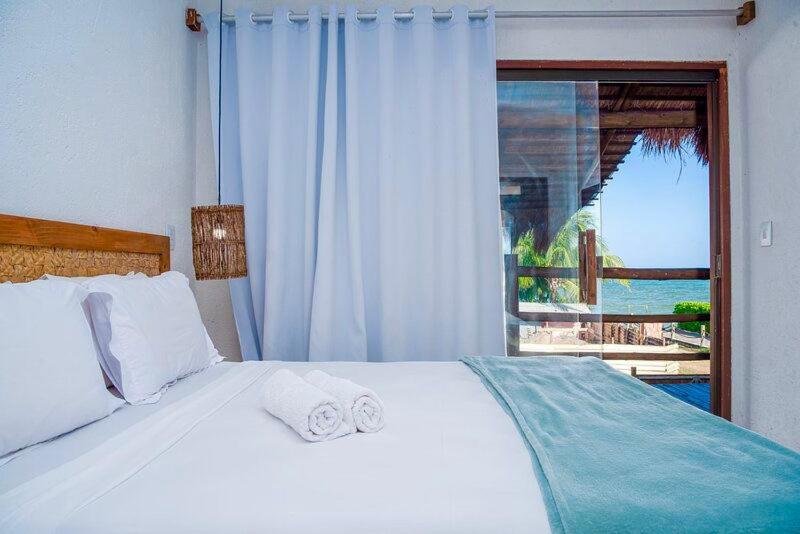 a bedroom with a bed with a view of the ocean at Casa piscina privativa e vista-mar - Milagres in Passo de Camarajibe