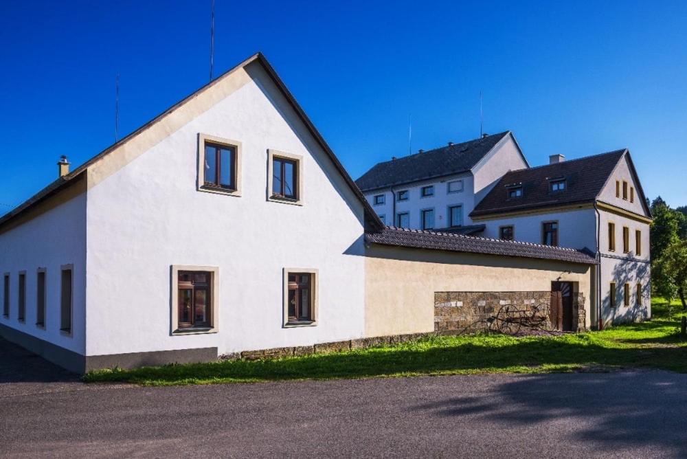a large white house with a black roof at Historická budova Třebovský mlýn v Dlouhé Třebové in Dlouhá Třebová