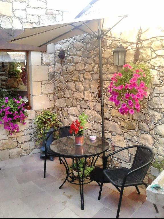 a table and chairs with an umbrella on a patio at Casa Rural Mi Rinconcillo in Valleruela de Pedraza
