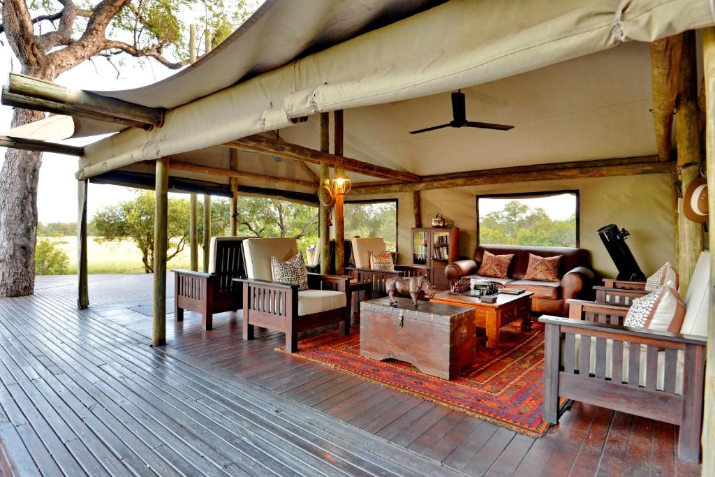 an outdoor living room with furniture on a deck at Rhino Walking Safaris in Skukuza