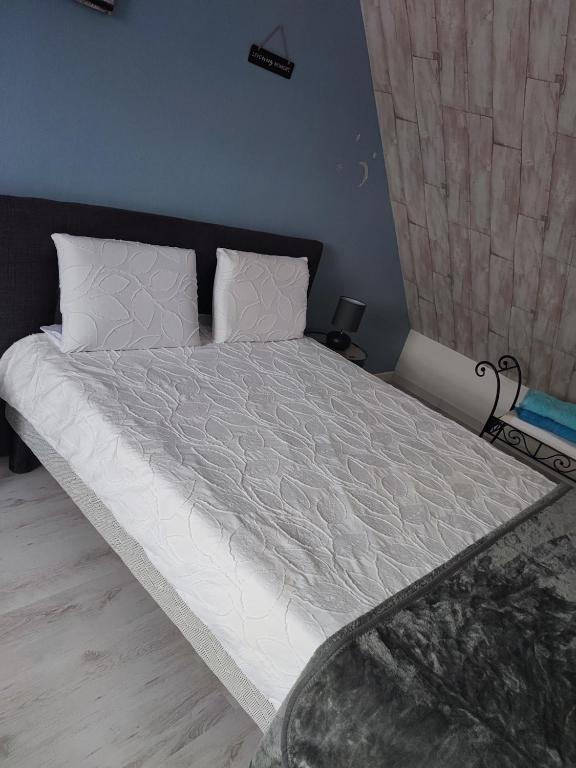 un lit avec des draps blancs et des oreillers dans une chambre dans l'établissement Monts repos!, à Monts