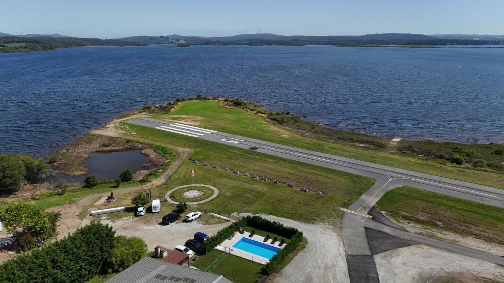 an island with a swimming pool next to a lake at Albergue Naturmaz in Mazaricos