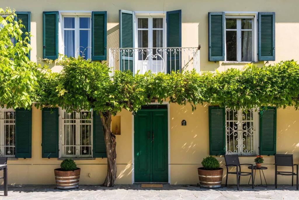 a building with green doors and windows at Luxe Villa, All Ensuites & Private Vineyard Views in San Marzano Oliveto