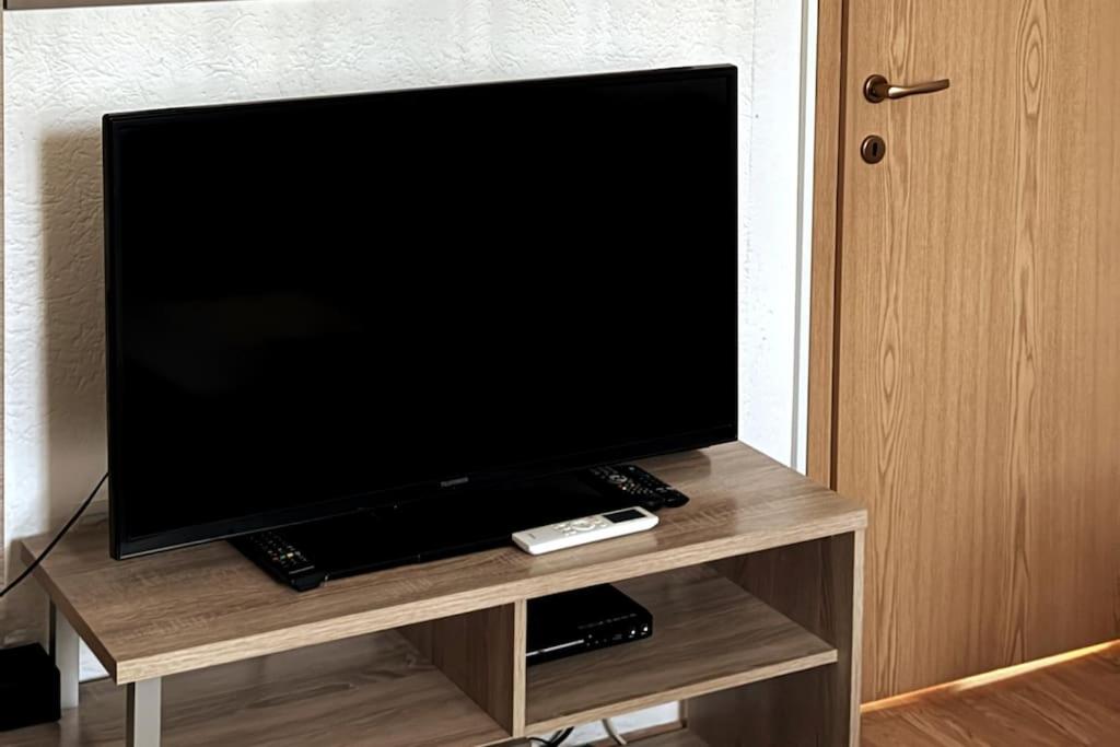 a flat screen tv sitting on a wooden entertainment center at Parkside Cozy Retreat in Pristina