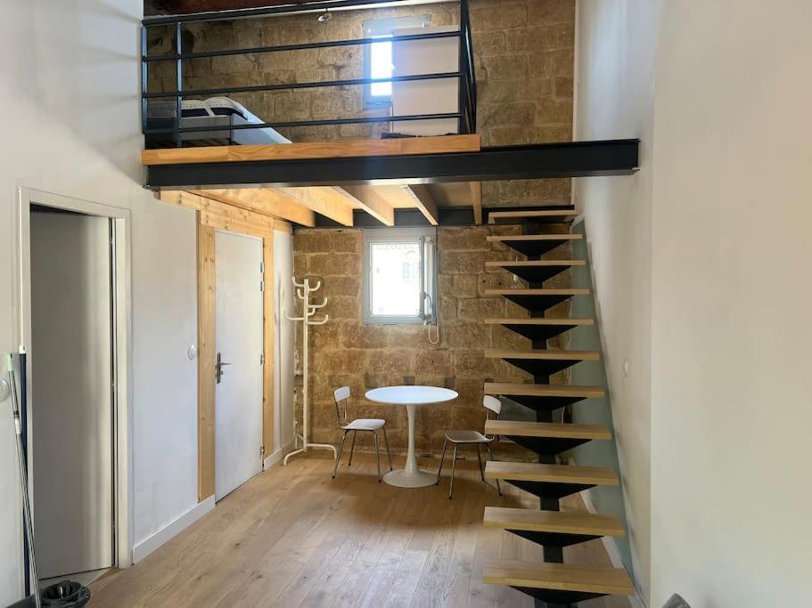 une mezzanine avec un escalier et une table dans une chambre dans l'établissement Le chat perché, à Montpellier