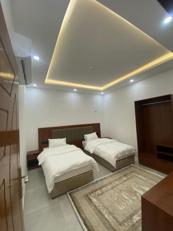 two beds in a room with at قصر أباهي للوحدات السكنية المفروشة in Al Nairyah