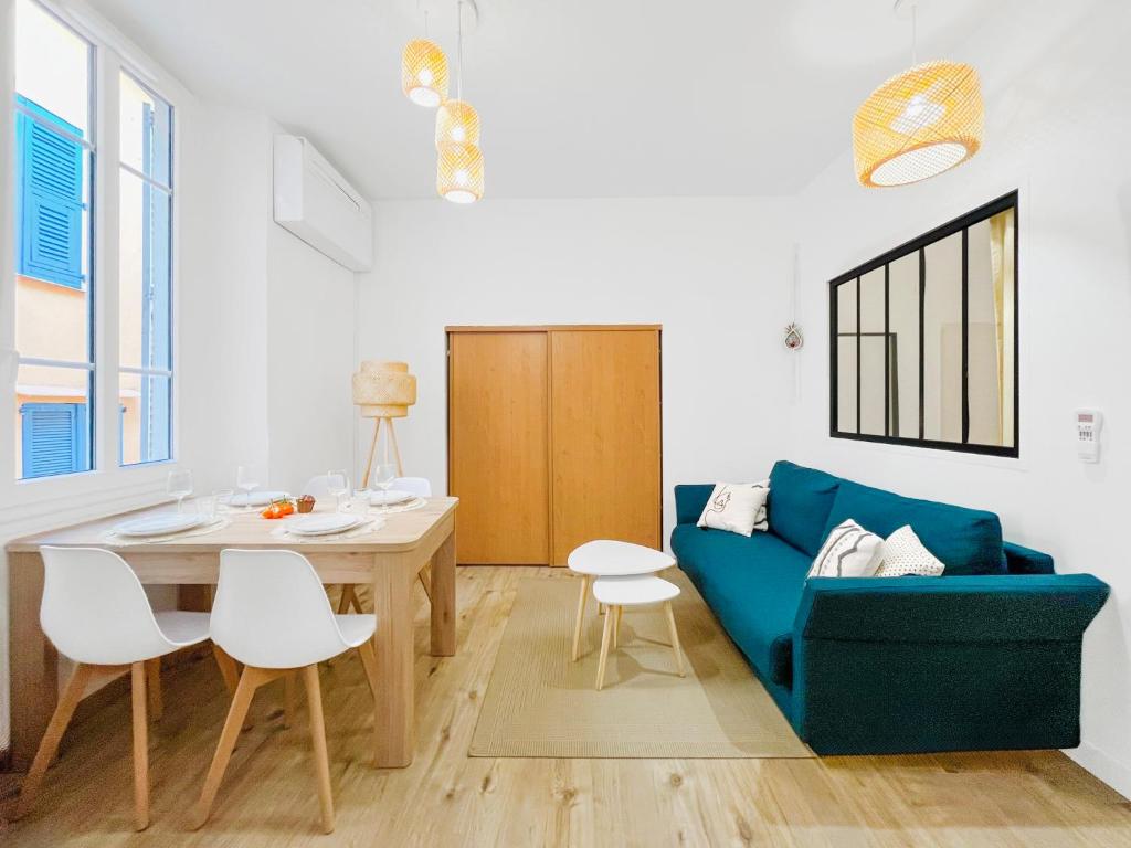un salon avec un canapé bleu et une table dans l'établissement L’Iris - Suquet Cannes Centre, à Cannes