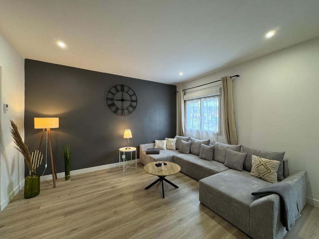 un salon avec un canapé gris et une table dans l'établissement Le Bener - Proche Centre - 6 pers, à Yvré-lʼÉvêque