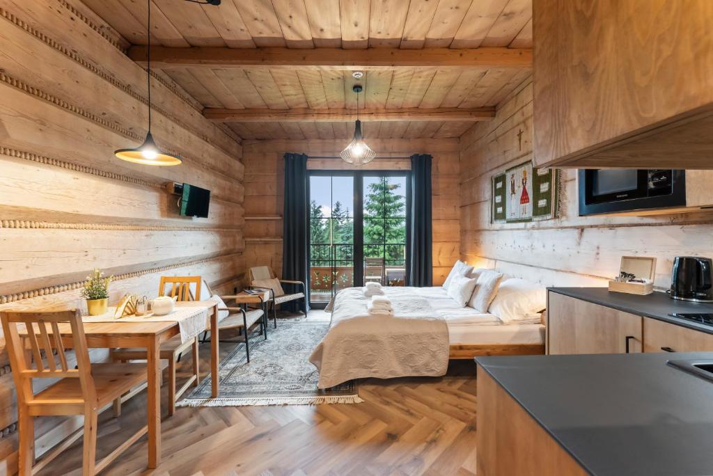 een woonkamer met een bed en een eetkamer bij Nowy Szlak Luksusowe Apartamenty in Kościelisko