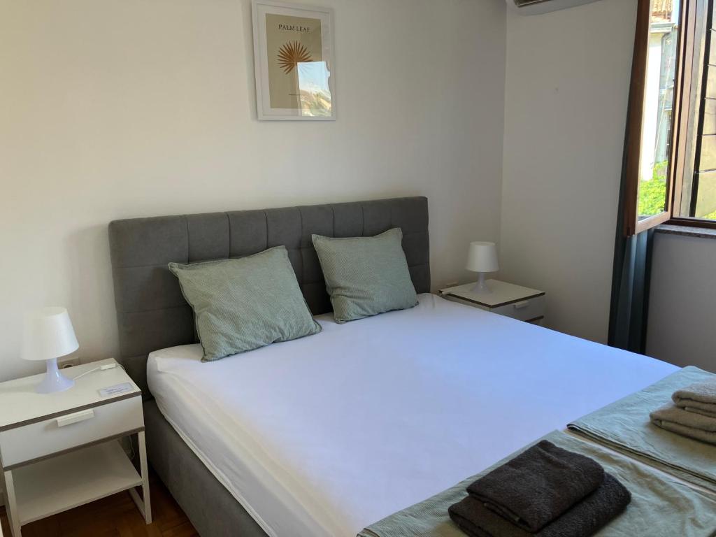 a bedroom with a large bed and two night stands at Guest House Marta in Rovinj