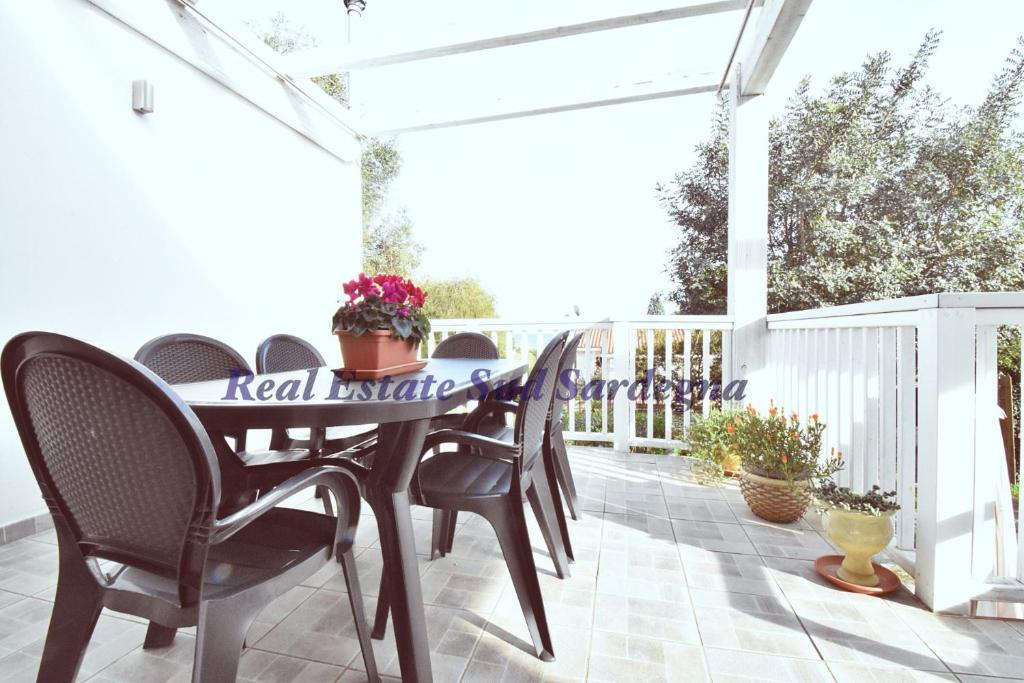 a dining table and chairs on a patio at Villa Virginia in Sarroch