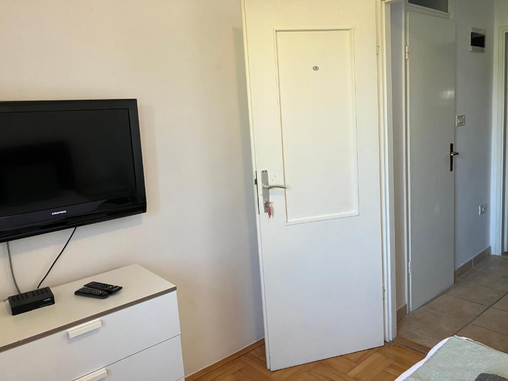 a room with a flat screen tv and a white door at Guest House Marta in Rovinj