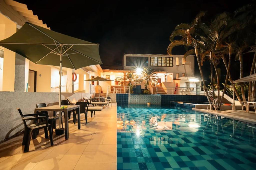 a pool with tables and chairs and an umbrella at hotel turqueza inn in Armenia