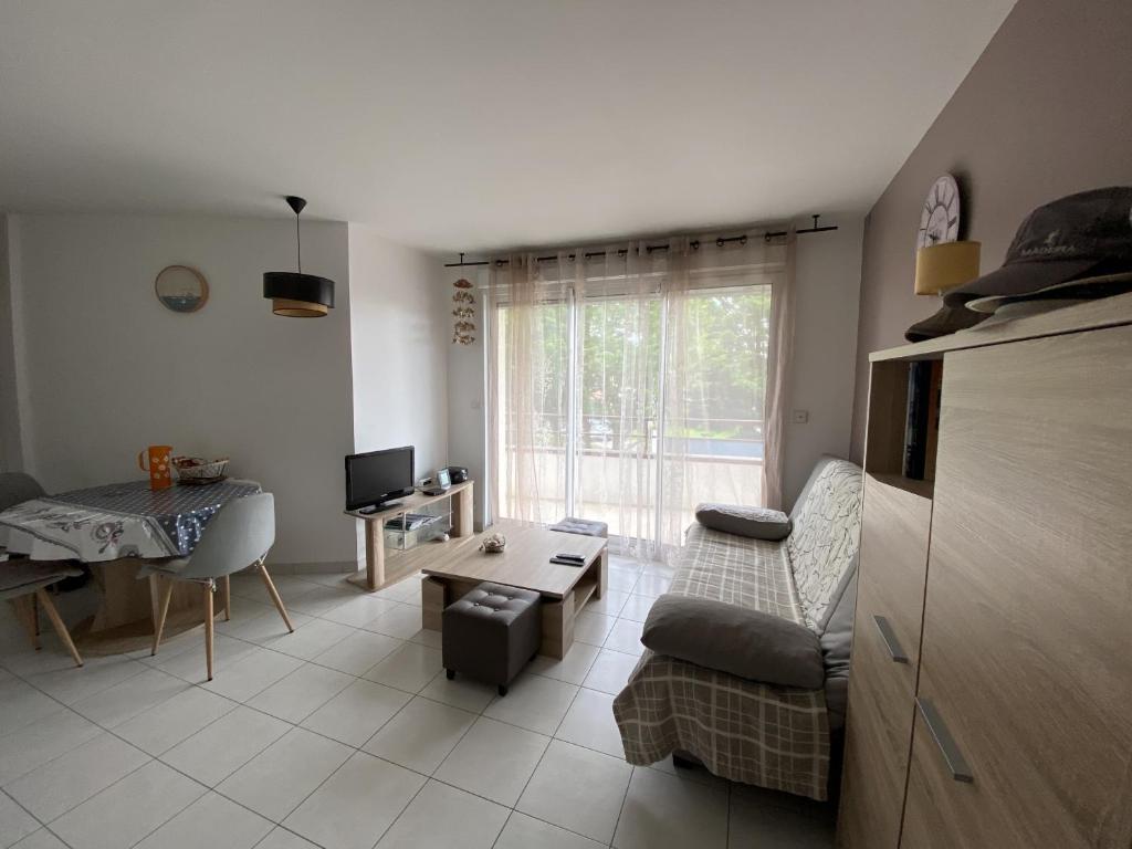 un salon avec un canapé et une table dans l'établissement Appartement Calme Puits d Enfer Parking, à Château-dʼOlonne