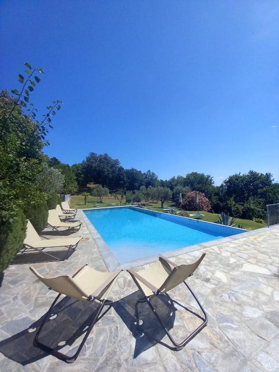 a group of chairs sitting next to a swimming pool at Casolare il Moro in Monte San Savino