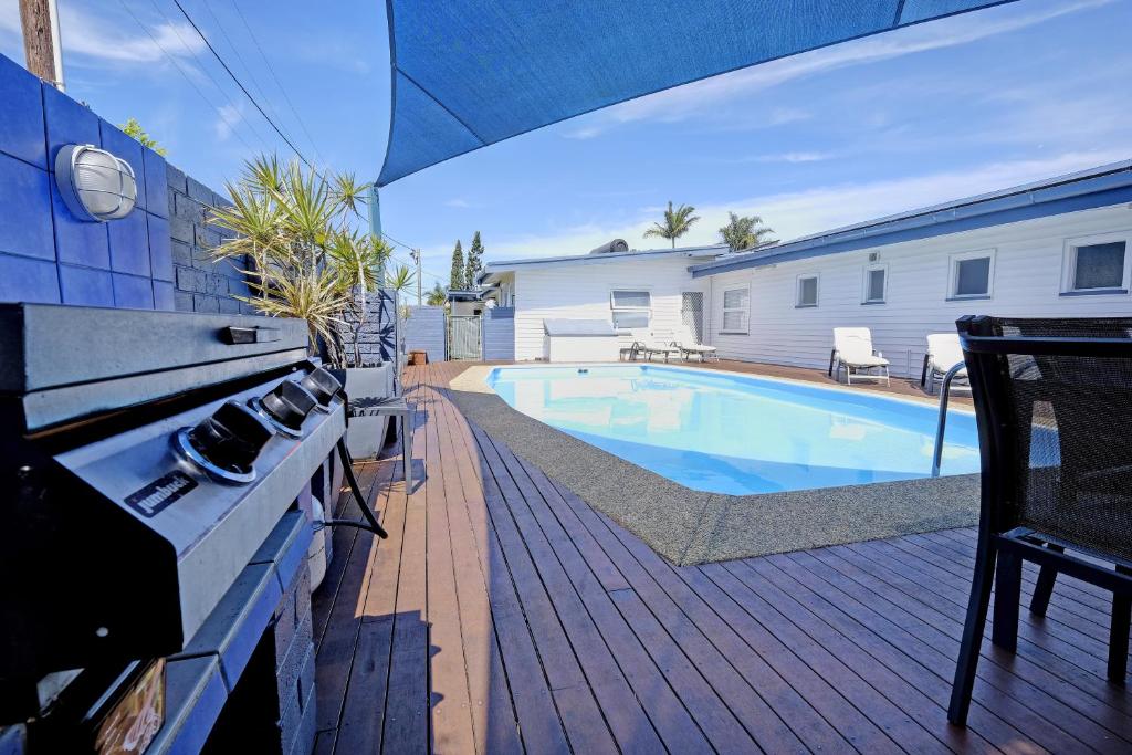 a backyard with a swimming pool and a house at Bali Hi Motel in Tuncurry