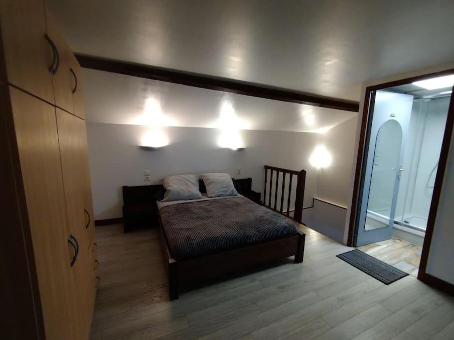 une chambre avec un lit et un grand miroir dans l'établissement Petite maison de village, à Chamouilley