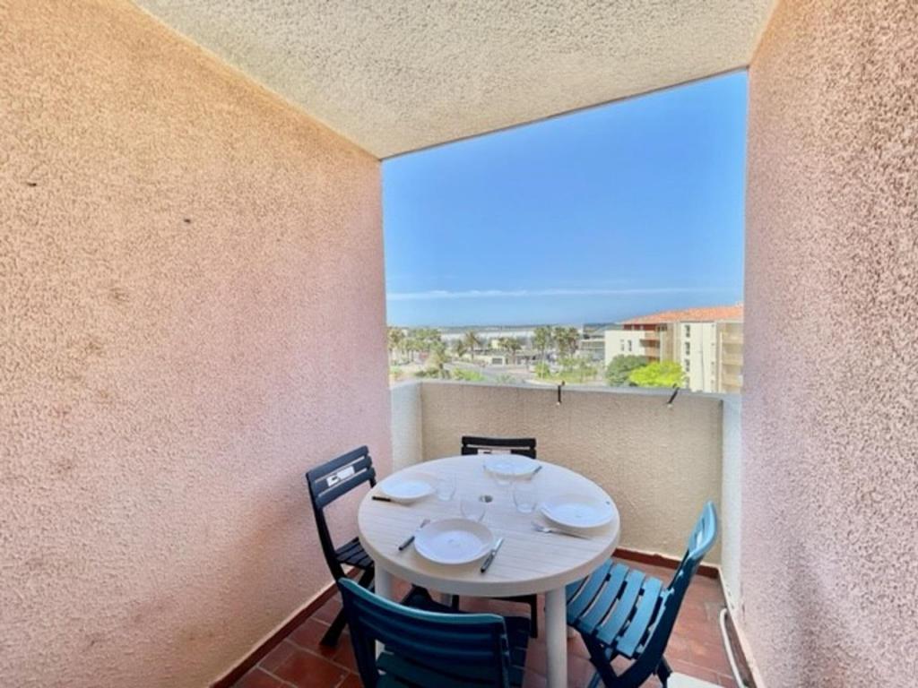 une salle à manger avec une table et des chaises sur un balcon dans l'établissement Studio cabine climatisé avec terrasse, parking privé, à 500m de la plage - FR-1-338-35, à Sète