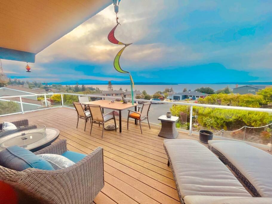 a patio with a table and chairs on a deck at Luxury Vacation House with Breathtaking Soundview in Federal Way