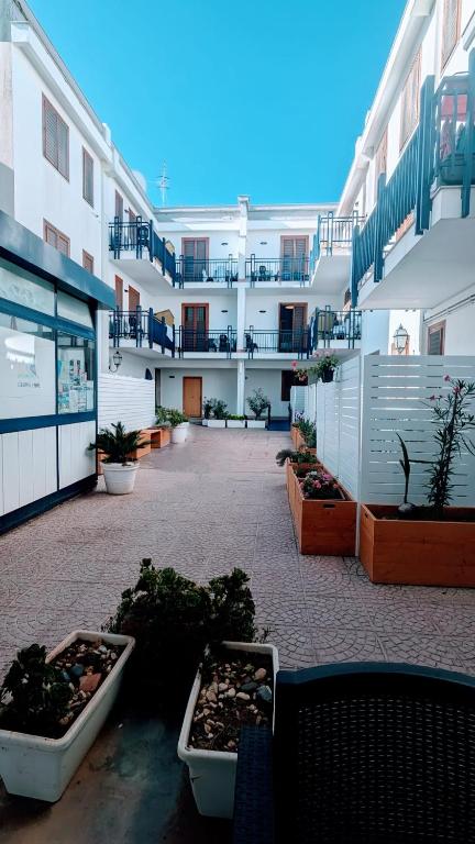 a courtyard of an apartment building with potted plants at Residence Marinella in San Vito lo Capo