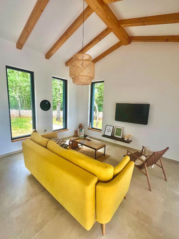 żółtą kanapę w salonie z telewizorem w obiekcie Casa Bosca with heated pool w mieście Sveti Petar u Šumi