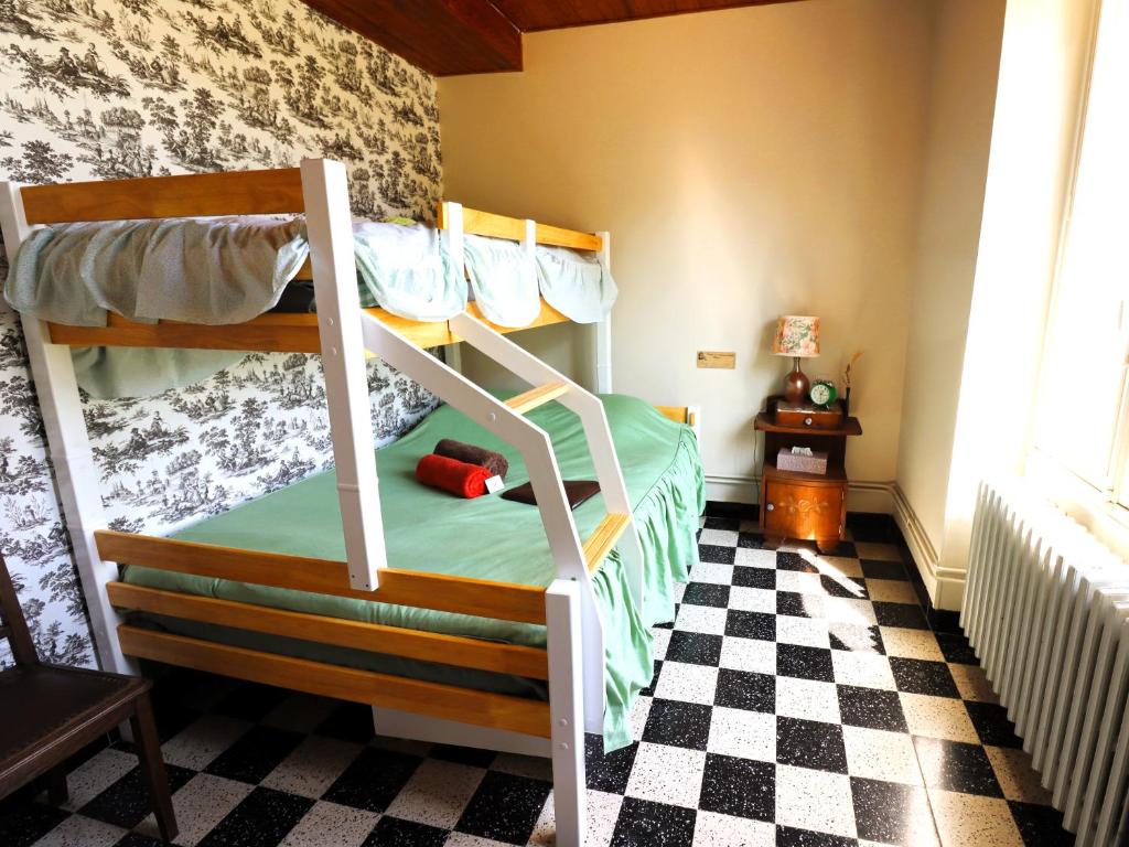 2 Etagenbetten in einem Zimmer mit einem karierten Boden in der Unterkunft Maison Bienvenue chez Mémé in Treigny
