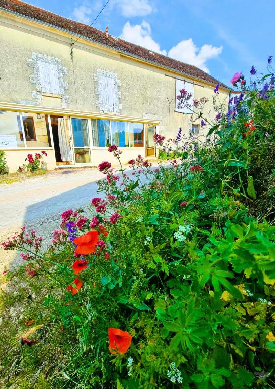 a group of flowers in front of a building at Maison Bienvenue chez Mémé in Treigny