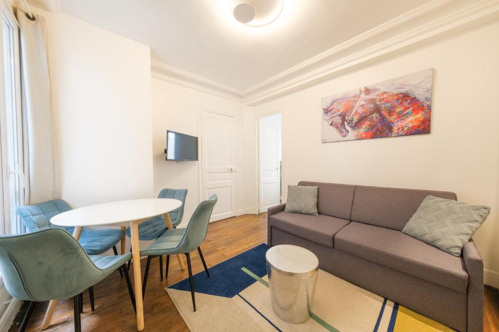 un salon avec un canapé et une table dans l'établissement Mgic Apartment 4p Montmartre, à Paris
