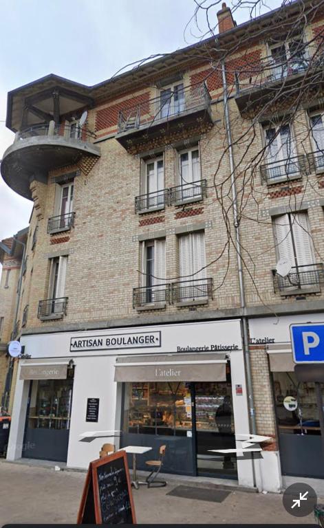 un bâtiment avec une enseigne devant lui dans l'établissement Cité jardin, à Stains