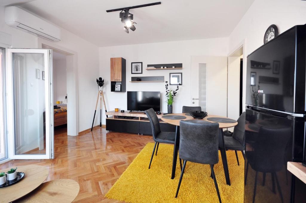 a kitchen and living room with a table and chairs at Apartman Chaplin in Vrnjačka Banja