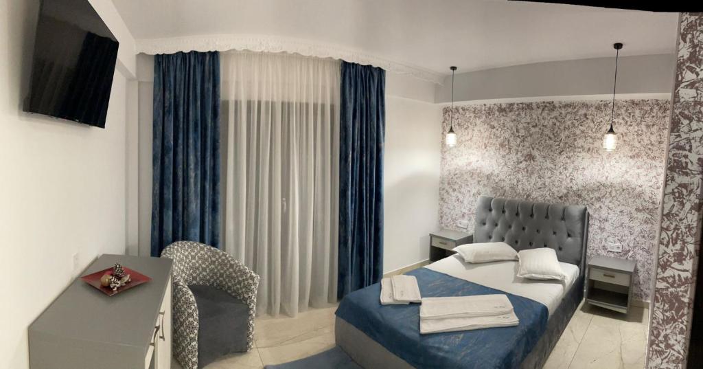 a bedroom with a bed and a table and a chair at Pensiunea El Ryo 1 in Călimăneşti