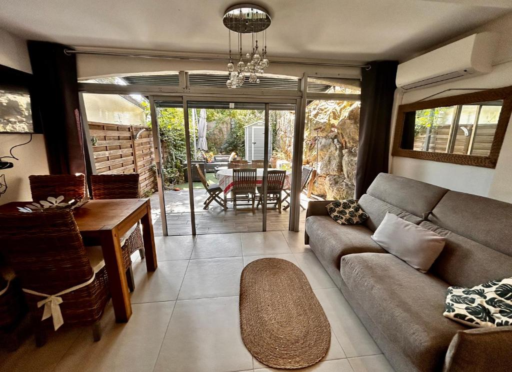 un salon avec un canapé et une table dans l'établissement Superbe appartement 2 pièces avec piscine et parking, proche de la mer, à Villeneuve-Loubet