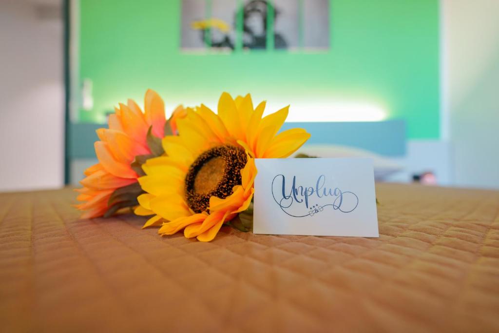 a bouquet of sunflowers sitting next to a sign at Unplug in Quartu SantʼElena