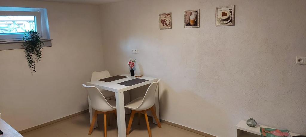 - une petite table et des chaises blanches dans la chambre dans l'établissement Ferienwohnung Bad Rotenfels, à Gaggenau